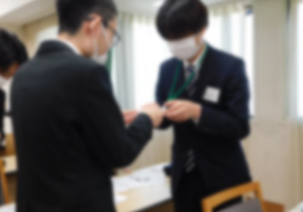 名刺交換を行う新入社員